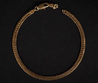 un bracelet en or avec un fermoir en forme de serpent sur fond noir
