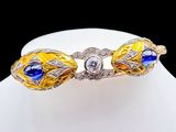 an image of a gold bracelet with blue and white stones on a mannequin
