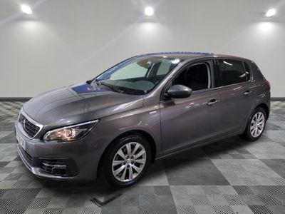une voiture grise est garée dans une pièce au sol à carreaux