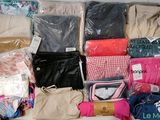 de nombreux sacs de vêtements posés sur un lit