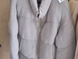 two jackets hanging on a clothes rack in a room