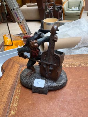 une figurine représentant un homme jouant du violon, posée sur une table