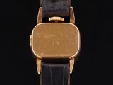 an image of a gold plated wrist watch with a black leather band