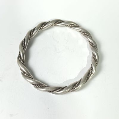 a close up of a silver bracelet on a white surface