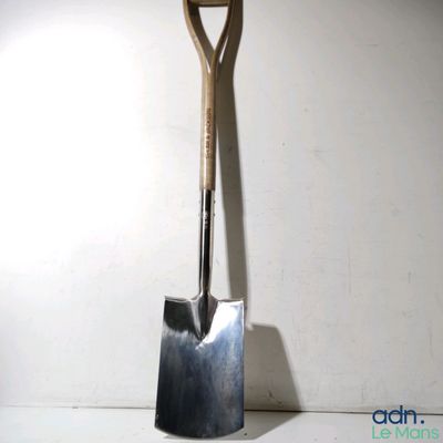 a shovel that is leaning up against a wall