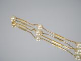 gold plated hair pins with pearls on them on a white background