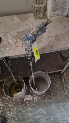 a dirty sink with two buckets of water in it