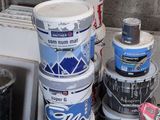 several buckets of paint are stacked on top of each other