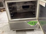 an open refrigerator sitting in the middle of a warehouse floor