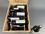 bottles of wine in a wooden box with a bottle of wine next to it