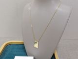 collier en or avec un pendentif carré, présenté sur un mannequin avec une petite carte