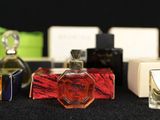 many perfume bottles lined up on a black table
