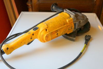 un outil électrique jaune et noir posé sur une table blanche