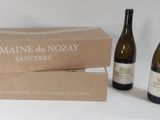 two bottles of wine are sitting next to a box of wine