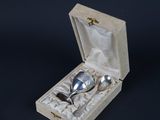 a silver spoon in a wooden box on a black background