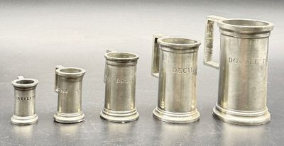 Ensemble de cinq verres doseurs en étain.
