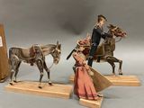 two figurines of a man and a woman on horses