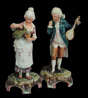 paire de figurines représentant un homme et une femme avec des instruments de musique