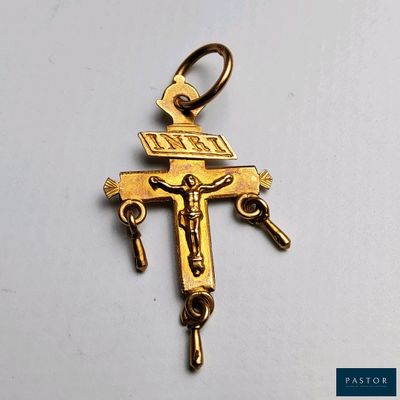 un gros plan d'une croix posée sur une surface blanche, sur laquelle figure une autre croix