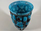a blue glass vase with a wire design on it