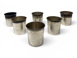 six silver cups are lined up in a row on a white surface