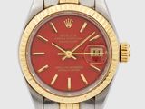 a close up of a wrist watch with a red dial
