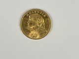gros plan d'une pièce d'or sur une surface blanche