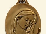 médaille d'or représentant une femme les yeux fermés sur fond blanc
