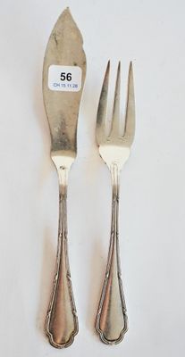 deux fourchettes et un couteau sur une table blanche