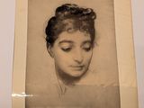 an old picture of a woman ' s face in a white frame
