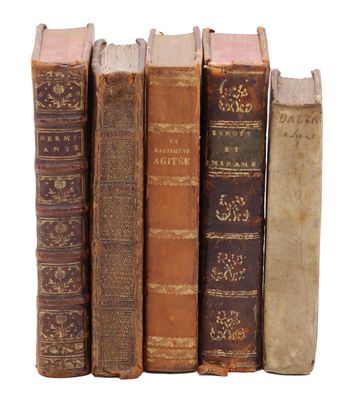 plusieurs vieux livres sont empilés sur une surface blanche