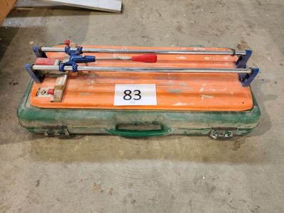 une valise orange munie d'une poignée bleue et d'une poignée rouge
