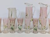 un ensemble de vases en verre rose ornés de fleurs peintes