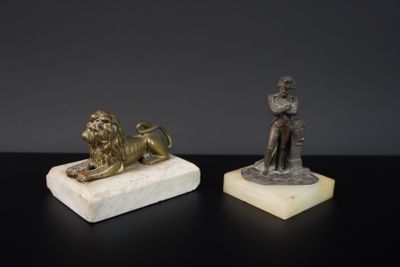 deux statues représentant un homme et un lion, posées sur un socle en marbre
