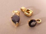 two pieces of gold and black stone jewelry on a table