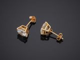 a pair of diamond stud earrings on a black background