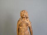 une statue représentant une femme debout sur un socle