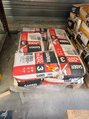 de nombreux sacs de ciment posés sur une palette dans le garage