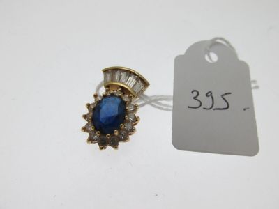 un gros plan d'une bague en pierre bleue et diamants sur une étiquette