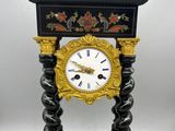 a black and gold clock sitting on top of a table