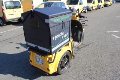 a yellow motorcycle with a black box on the back of it