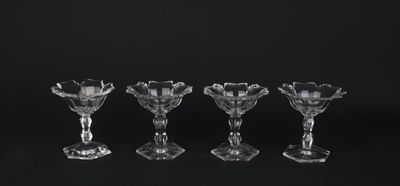quatre verres à vin en cristal sont alignés sur une surface noire