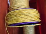 un gros plan sur une corde jaune dans une boîte ornée d'un ruban violet