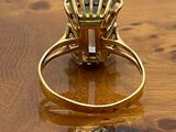 a gold ring with a blue stone on a wooden table