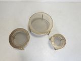three pieces of brass are sitting on a white surface