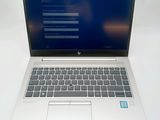a white laptop with a blue screen on a white table