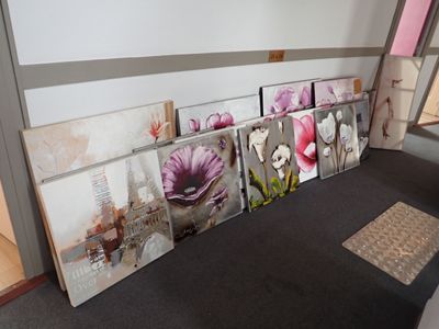 Il y a de nombreuses photos de fleurs accrochées au mur dans cette pièce