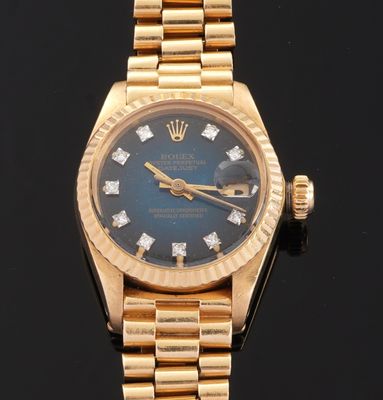 an image of a gold wrist watch with blue dial and diamonds