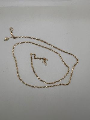 a close up of a gold chain with a cross on it