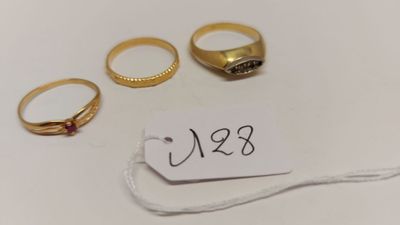 trois bagues en or et une étiquette de prix sur un fond blanc